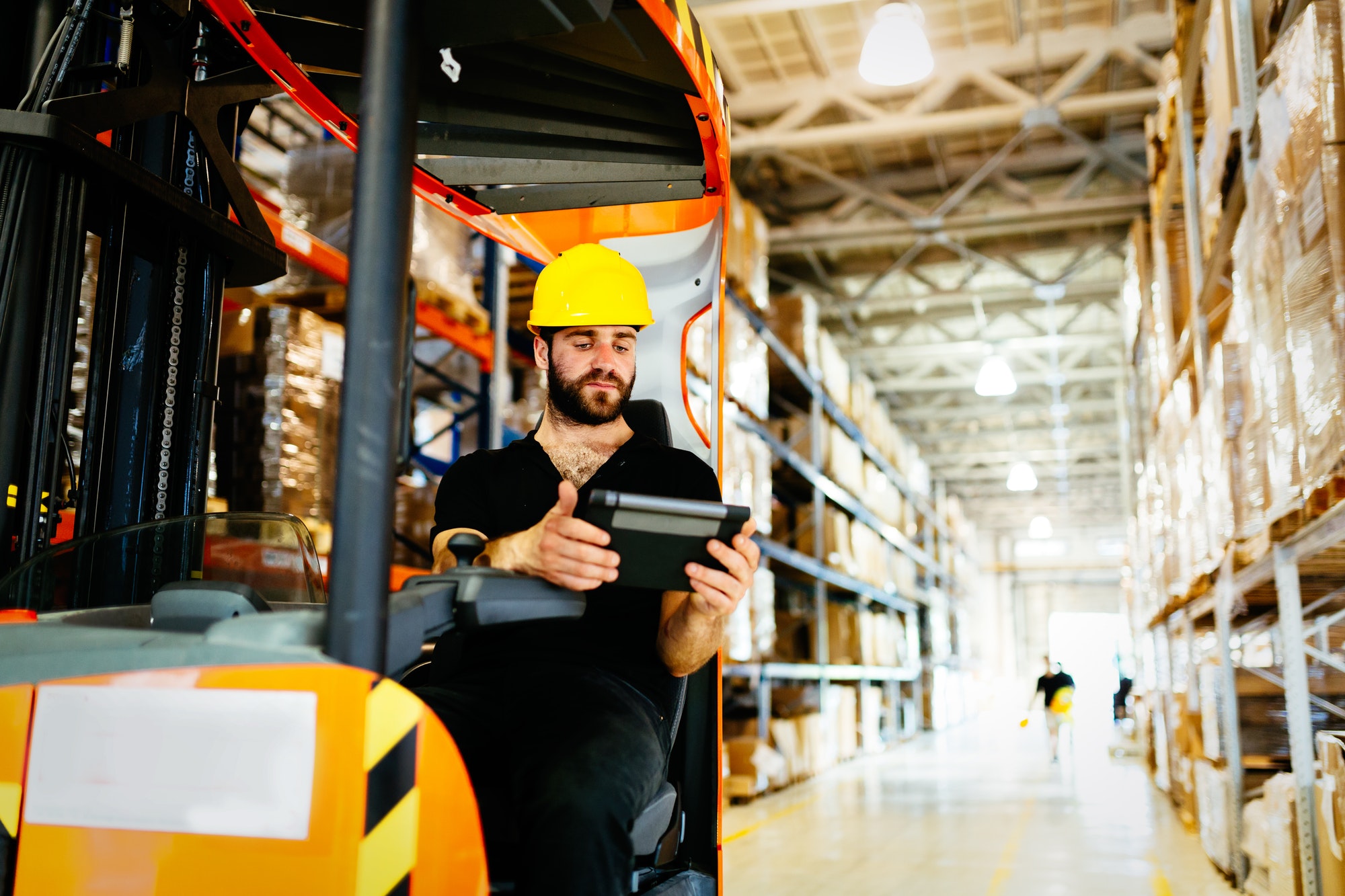 Warehouse worker doing logistics work with forklift loader